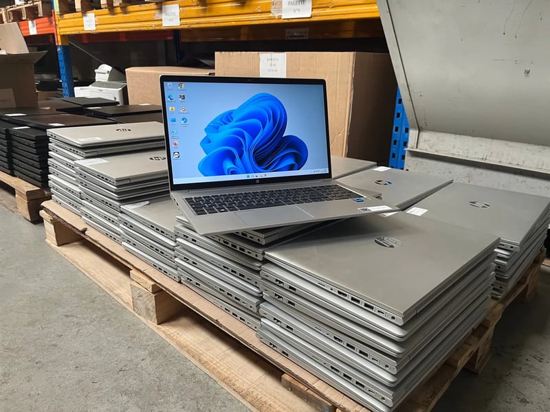 Ordinateurs portables regroupés sur une palette, un ordinateur ouvert